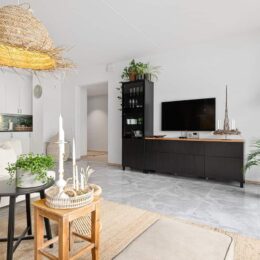 Un élégant "meuble TV ergonomiques" de couleur blanche, avec des étagères et des tiroirs de rangement, conçu pour optimiser l'espace et le confort